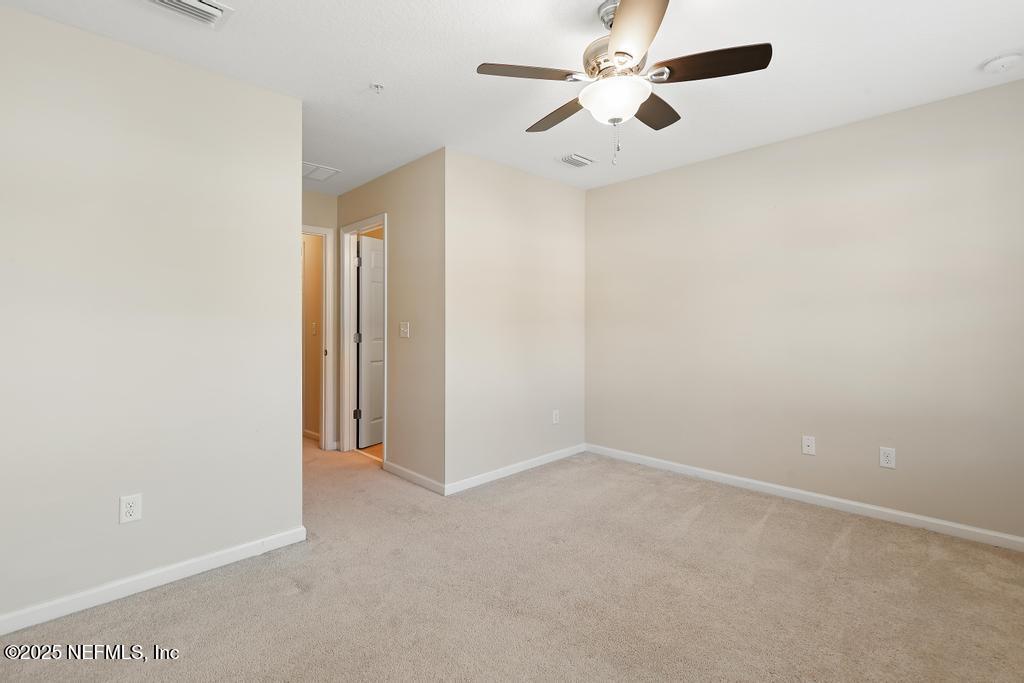 102 San Briso Way St. Augustine, FL 32092 - Photo 39 of 62 an empty room with a chandelier fan and windows