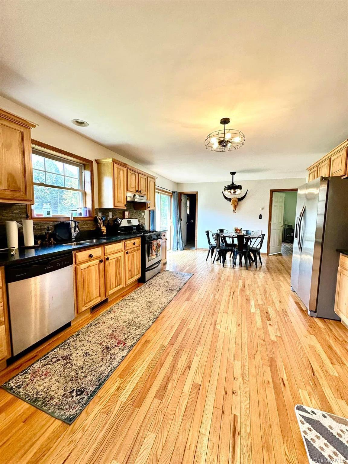 595 Hurd And Parks Road Swan Lake, NY 12783 - Photo 19 of 43 Kitchen featuring stainless steel appliances, healthy amount of natural light, light wood-type flooring, and dark countertops
