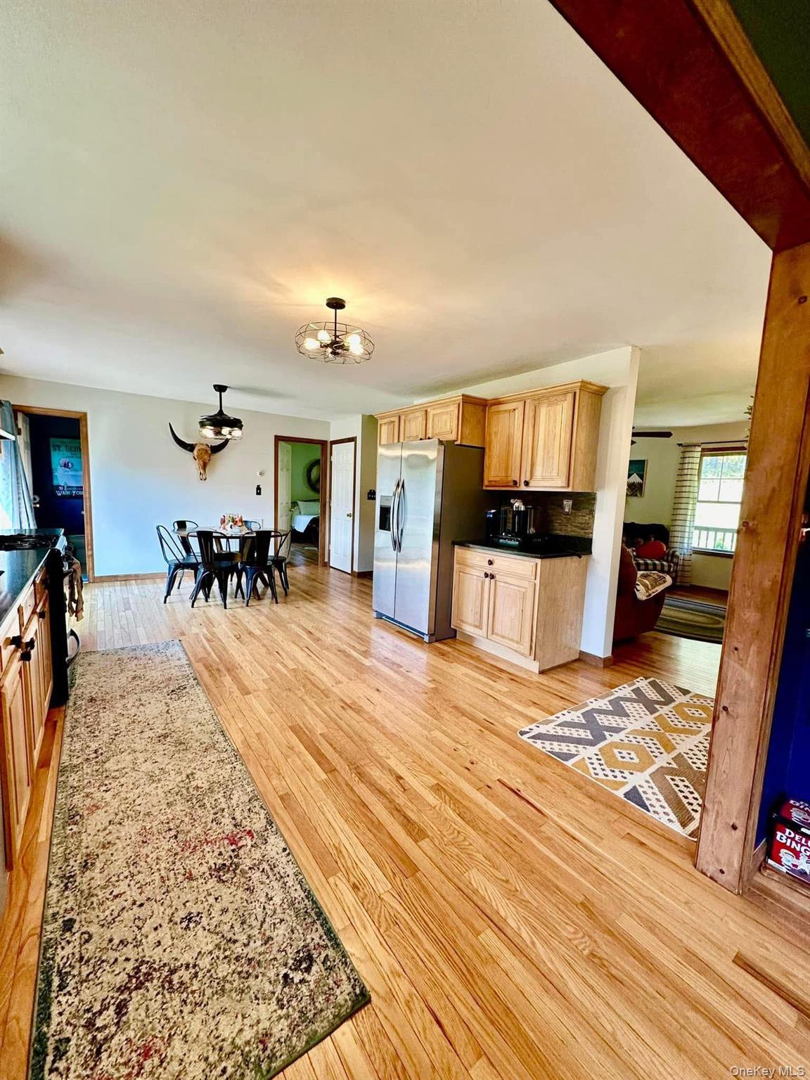 595 Hurd And Parks Road Swan Lake, NY 12783 - Photo 20 of 43 Kitchen featuring light wood-style flooring, light brown cabinetry, stainless steel fridge with ice dispenser, and backsplash
