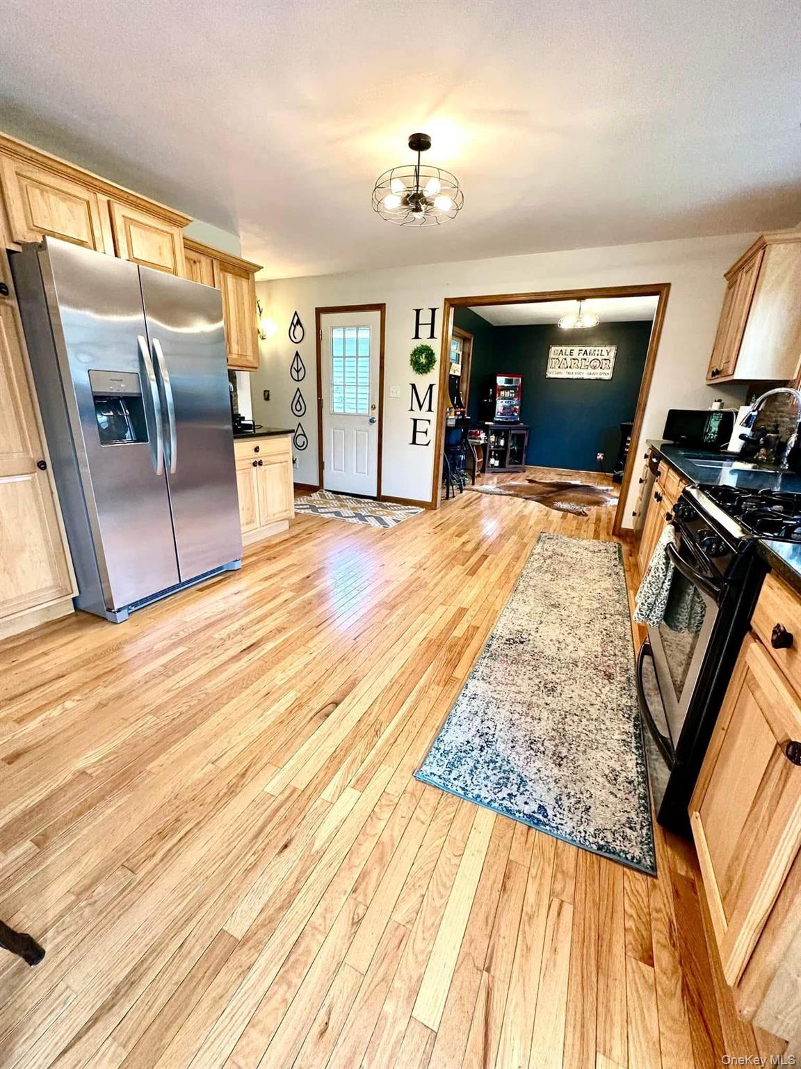 595 Hurd And Parks Road Swan Lake, NY 12783 - Photo 21 of 43 Kitchen featuring stainless steel refrigerator with ice dispenser, range with gas stovetop, dark countertops, and light brown cabinetry