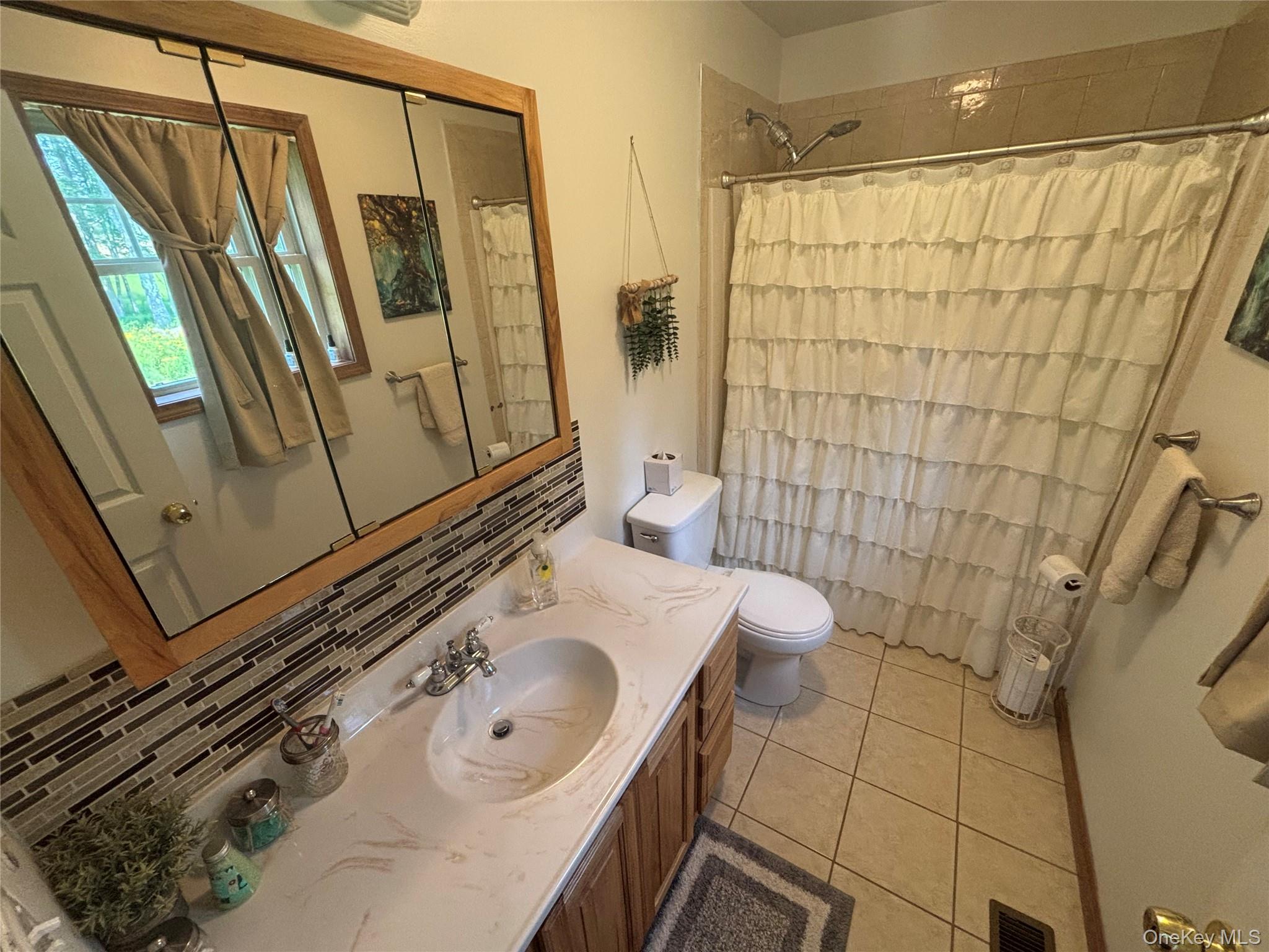 595 Hurd And Parks Road Swan Lake, NY 12783 - Photo 32 of 43 Full bath featuring tile patterned floors, vanity, and a shower with curtain