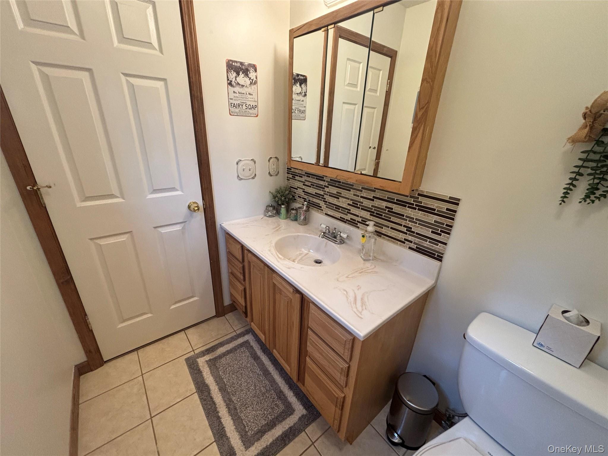 595 Hurd And Parks Road Swan Lake, NY 12783 - Photo 33 of 43 Bathroom featuring backsplash, vanity, and tile patterned flooring