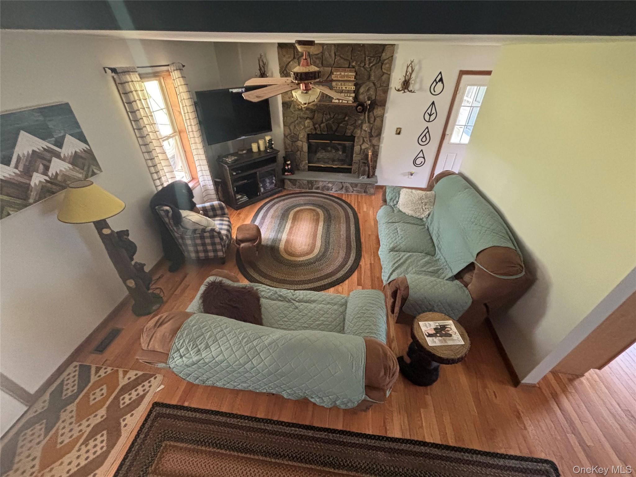 595 Hurd And Parks Road Swan Lake, NY 12783 - Photo 40 of 43 Living area with wood finished floors, a fireplace, and ceiling fan