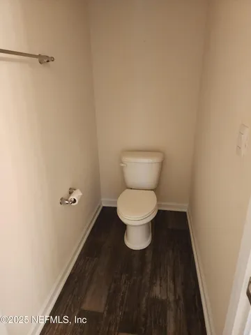 a white toilet sitting next to a white wall