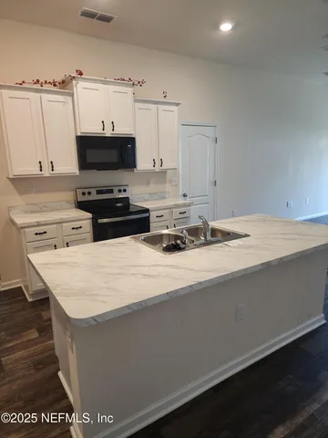 a kitchen with stainless steel appliances a sink a stove and a refrigerator