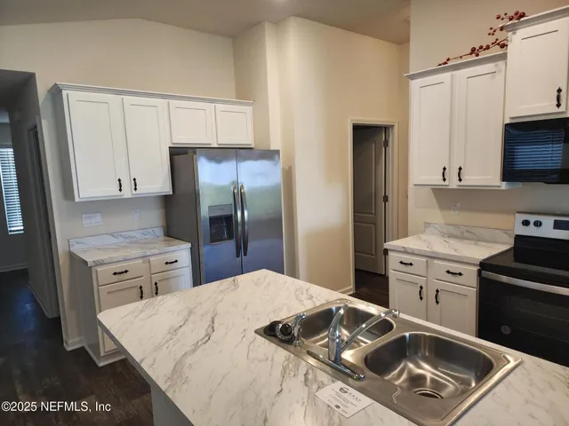 a kitchen with a stove a sink and a refrigerator