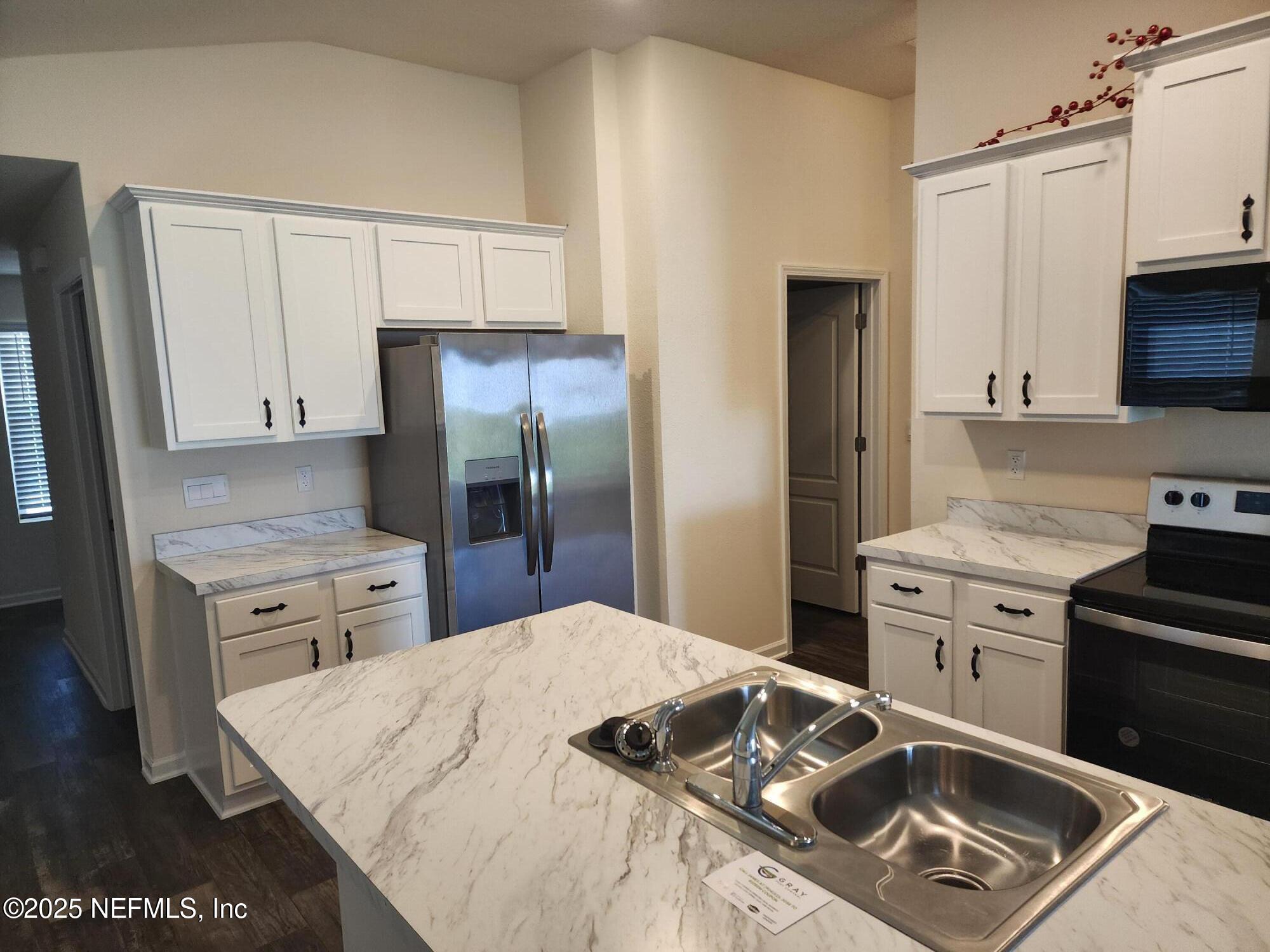 2295 Falling Star Ln Green Cove Springs Green Cove Springs, FL 32043 - Photo 6 of 24 a kitchen with a stove a sink and a refrigerator