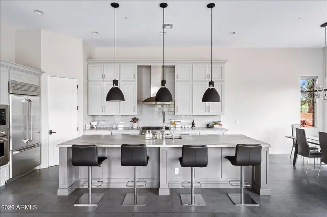 a kitchen with stainless steel appliances kitchen island granite countertop a table and chairs
