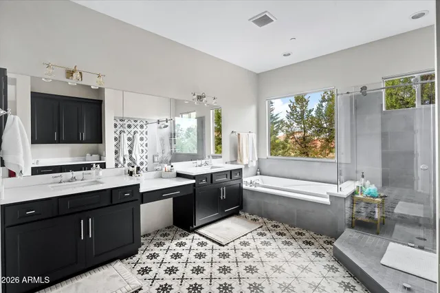 a large bathroom with a sink double vanity granite tub and shower