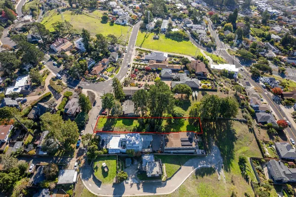 an aerial view of residential houses with outdoor space and swimming pool