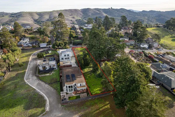 an aerial view of a house with a mountain