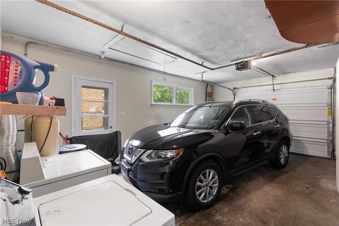 5768 Nolley Road Akron, OH 44319 - Photo 19 of 38 Garage interior featuring a sectional overhead door, concrete flooring, white painted walls, and a side entry door with glass panes