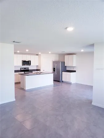 a view of kitchen with kitchen island and stainless steel appliances