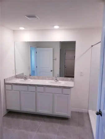 a bathroom with a double vanity sink and a mirror