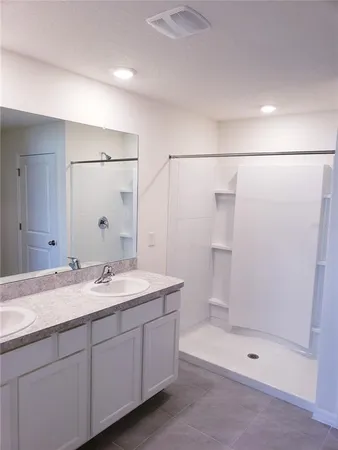 a bathroom with a granite countertop sink a mirror a shower and a mirror
