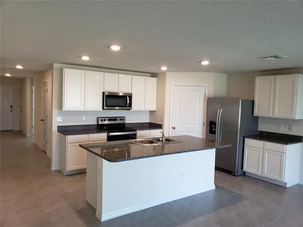 a kitchen with stainless steel appliances granite countertop a refrigerator sink and stove