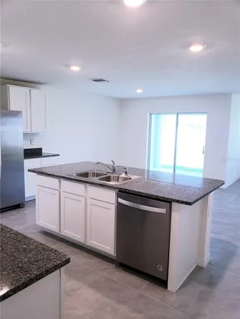 a kitchen with granite countertop a sink and a stove