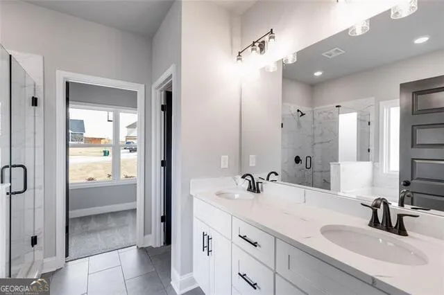 a bathroom with a shower sink and mirror