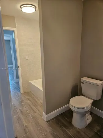 a white toilet sitting next to a shower