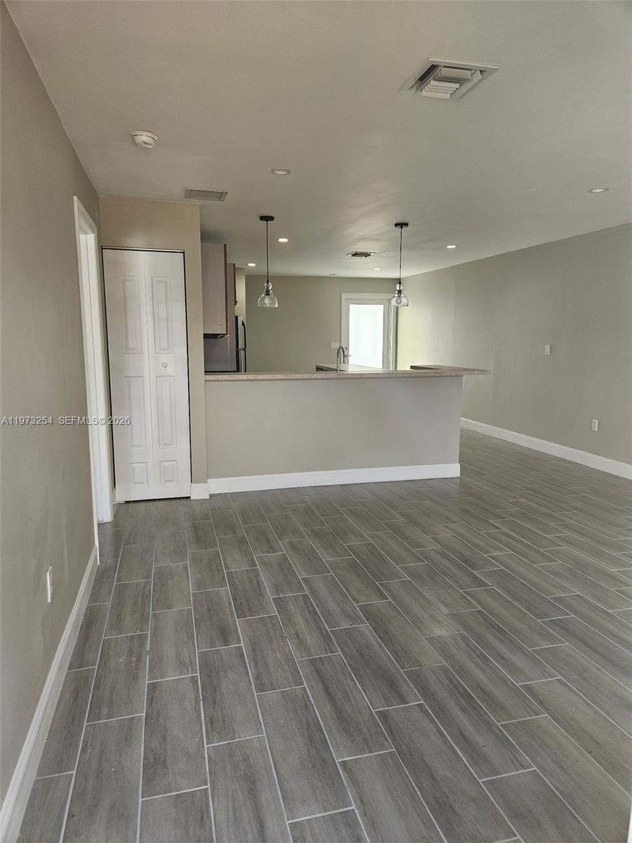 3906 Northwest 207 St Road, Unit 3906 Miami Gardens, FL 33055 - Photo 8 of 26 an empty room with wooden floor and windows