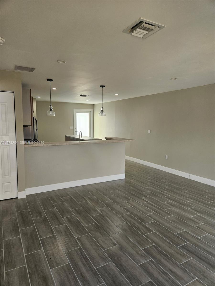 3906 Northwest 207 St Road, Unit 3906 Miami Gardens, FL 33055 - Photo 9 of 26 an empty room with wooden floor and windows