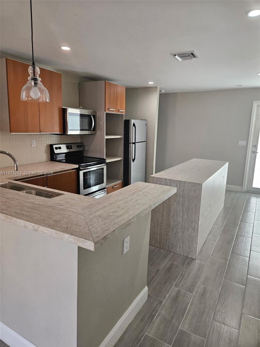 3906 Northwest 207 St Road, Unit 3906 Miami Gardens, FL 33055 - Photo 10 of 26 a kitchen with stainless steel appliances a sink a microwave a refrigerator and cabinets