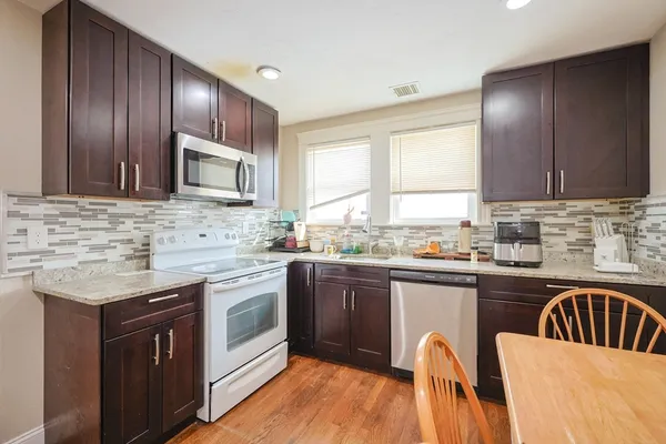 a kitchen with stainless steel appliances granite countertop a stove a sink dishwasher a microwave oven with granite countertops and cabinets