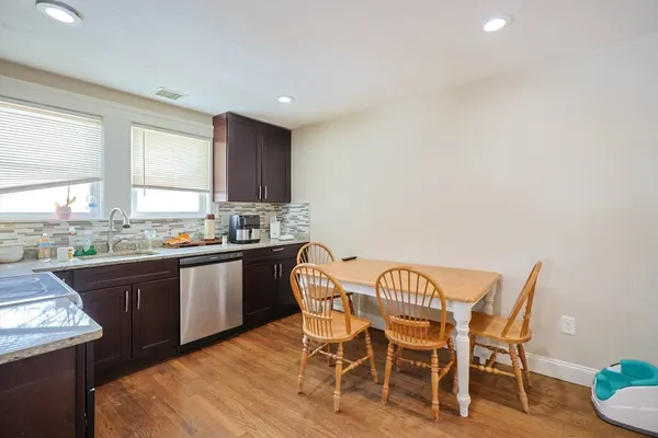 a kitchen with granite countertop dining table chairs and wooden cabinets