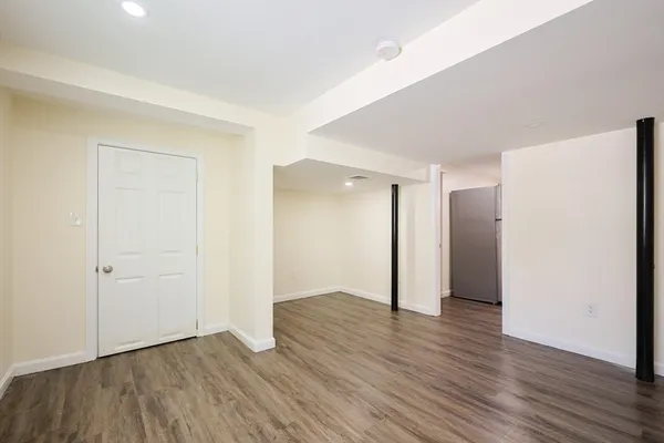 an empty room with wooden floor & closet area