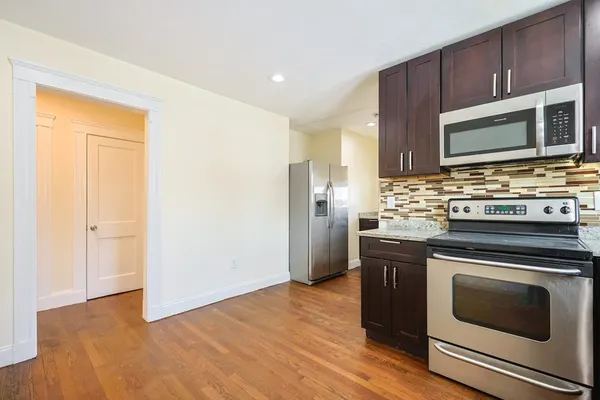 a kitchen with stainless steel appliances a stove a microwave and a hard wood floor