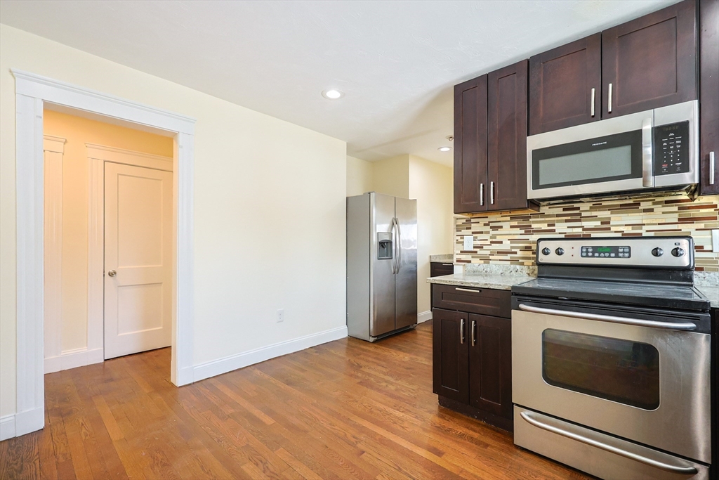 96 Mansfield Street Framingham, MA 01702 - Photo 4 of 39 a kitchen with stainless steel appliances a stove a microwave and a hard wood floor
