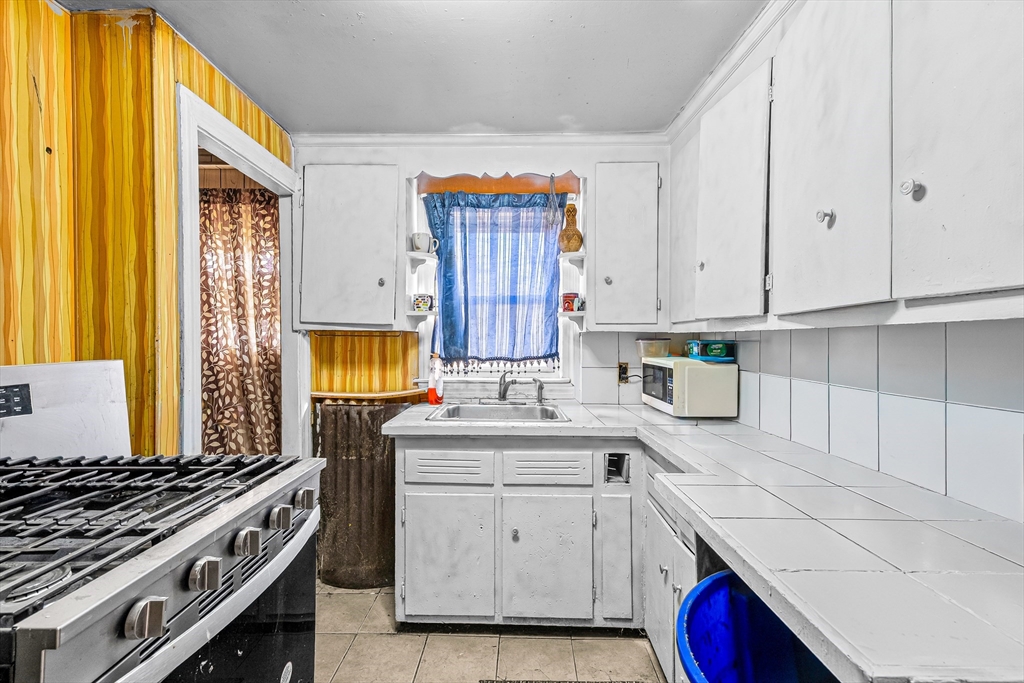 187 St Mary Street Needham, MA 02494 - Photo 12 of 28 a kitchen with granite countertop a sink a stove and cabinets