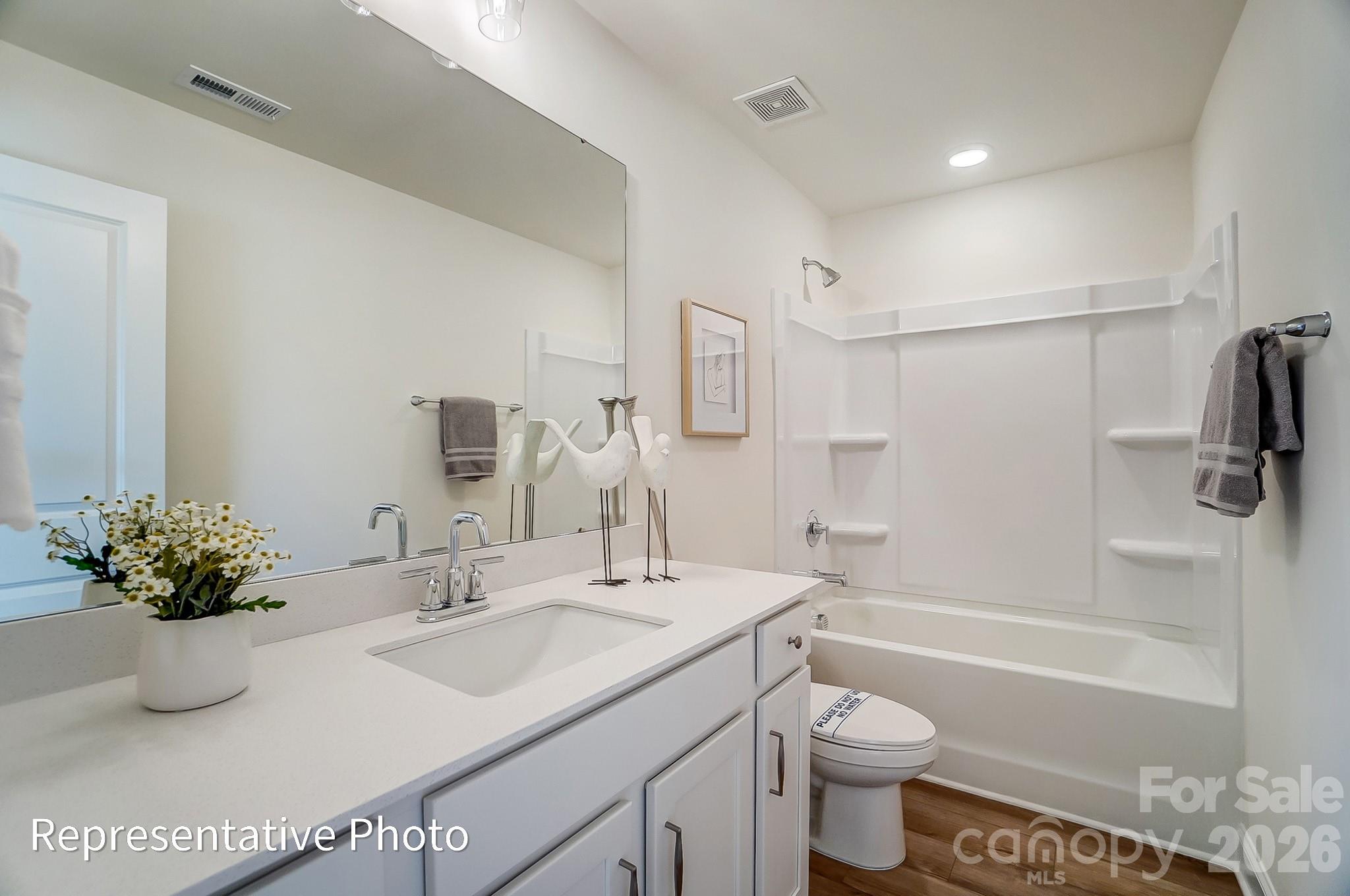 13127 Foxberry Road Charlotte, NC 28213 - Photo 22 of 24 a bathroom with a granite countertop sink a toilet and shower