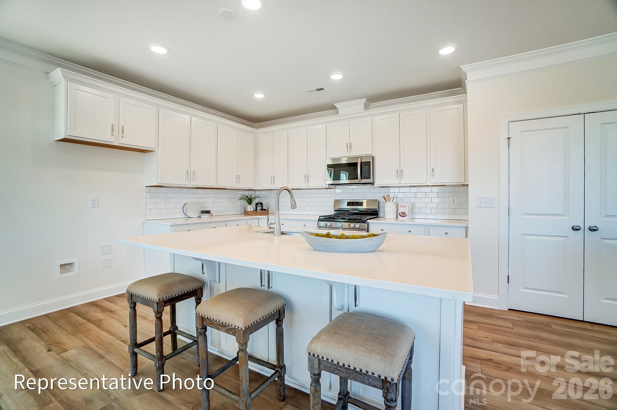 13127 Foxberry Road Charlotte, NC 28213 - Photo 6 of 24 a kitchen with stainless steel appliances a stove a sink a microwave a refrigerator and cabinets