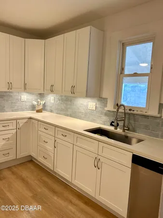 a kitchen with a sink cabinets and window