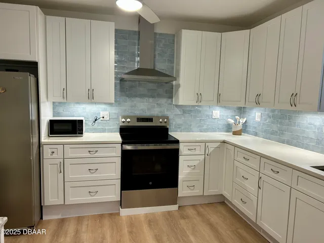 a kitchen with cabinets appliances and a counter space