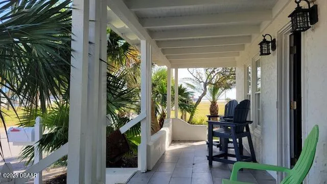 a view of a porch with chairs and potted plants