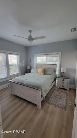 a bedroom with a large bed and a chandelier fan
