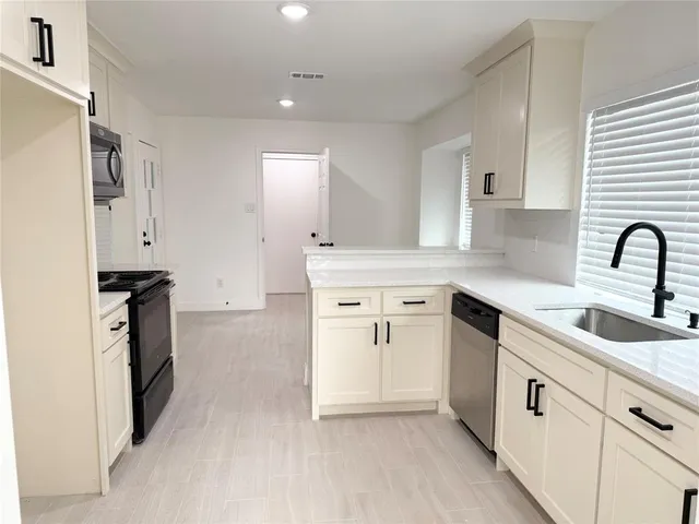 a kitchen with granite countertop a sink stove and refrigerator