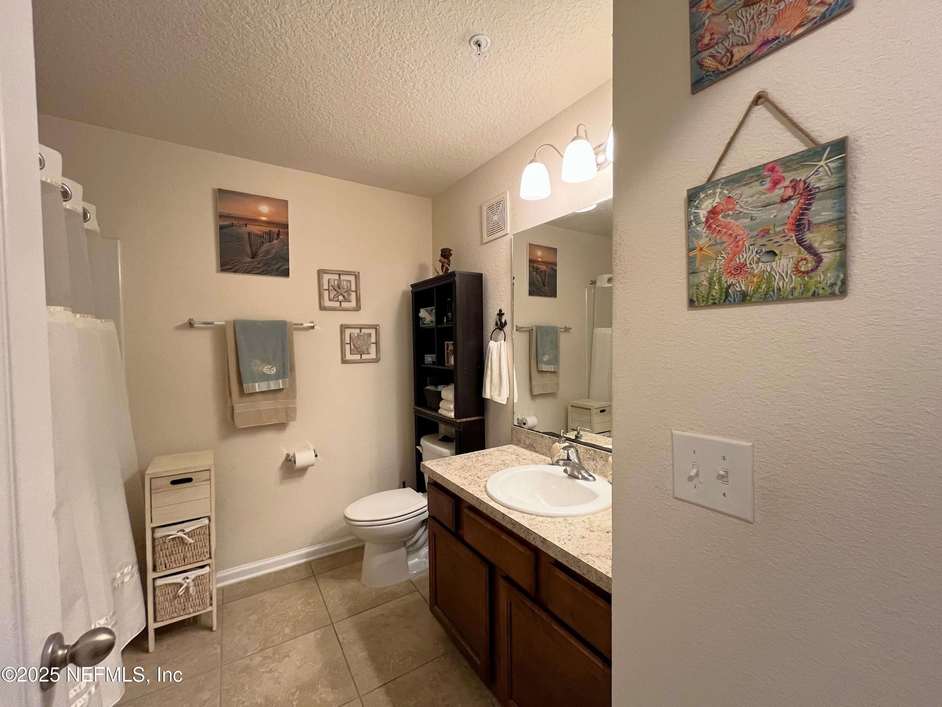 2103 Golden Lake Loop, Unit 2103 St. Augustine, FL 32084 - Photo 14 of 32 a bathroom with a granite countertop sink mirror vanity and toilet
