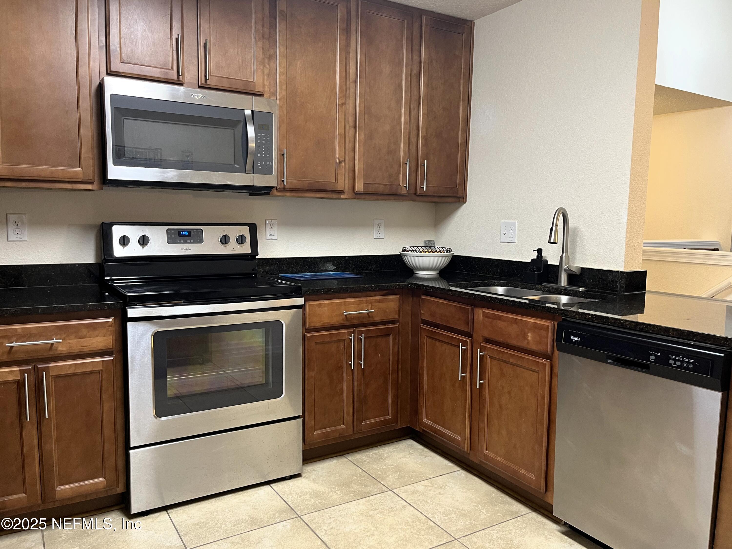 2103 Golden Lake Loop, Unit 2103 St. Augustine, FL 32084 - Photo 5 of 32 a kitchen with granite countertop cabinets and steel stainless steel appliances
