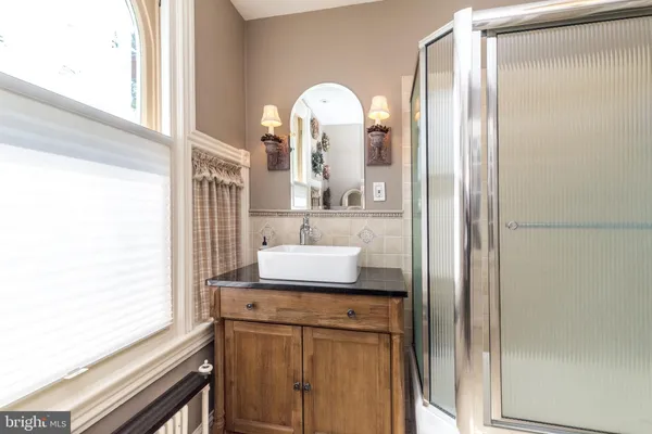 a bathroom with a granite countertop sink a toilet and shower