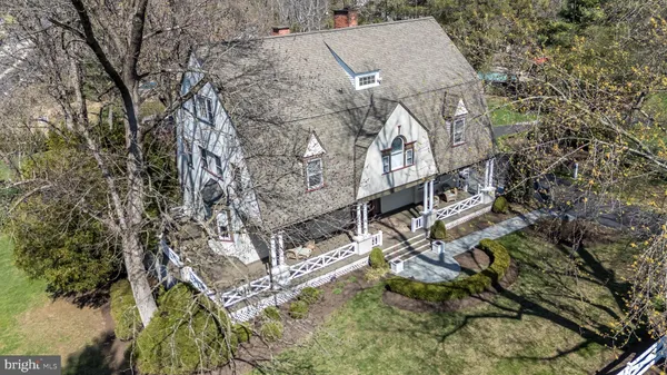 a aerial view of a house with a yard and large trees