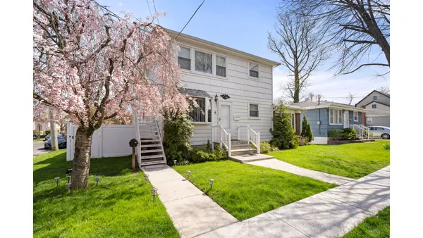 a front view of a house with a yard and trees