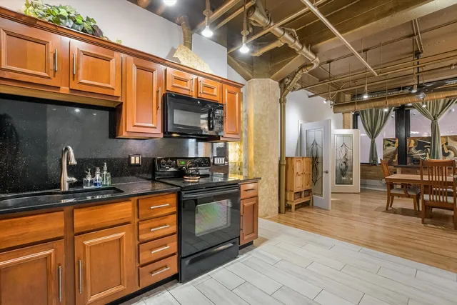 a kitchen with stainless steel appliances granite countertop a sink a stove and cabinets