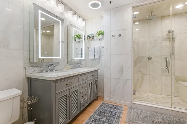 a bathroom with a double vanity sink toilet and shower