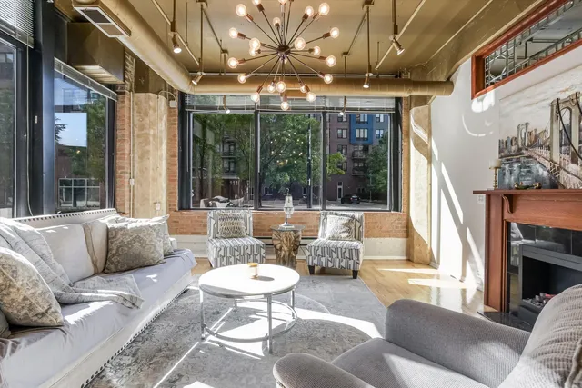 a living room with fireplace furniture and a large window
