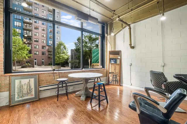 a living room with furniture a large window and wooden floor