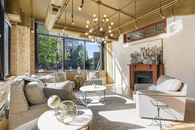 a living room with furniture chandelier and a fireplace