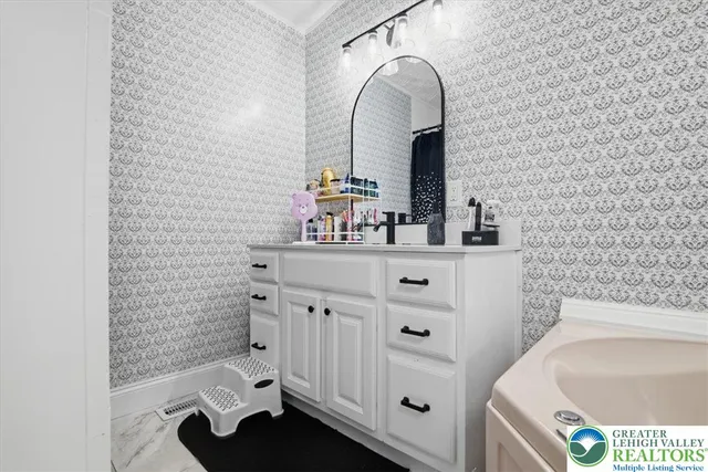 a view of a house with a large tree and wooden fence